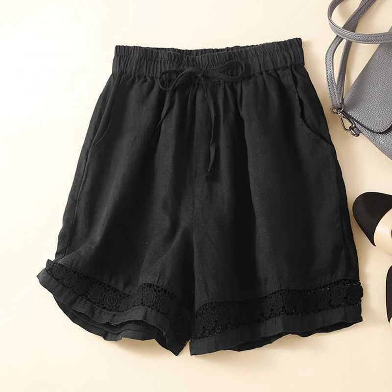Close-up of embroidered lace-inspired hem detail on relaxed floral shorts in a neutral color