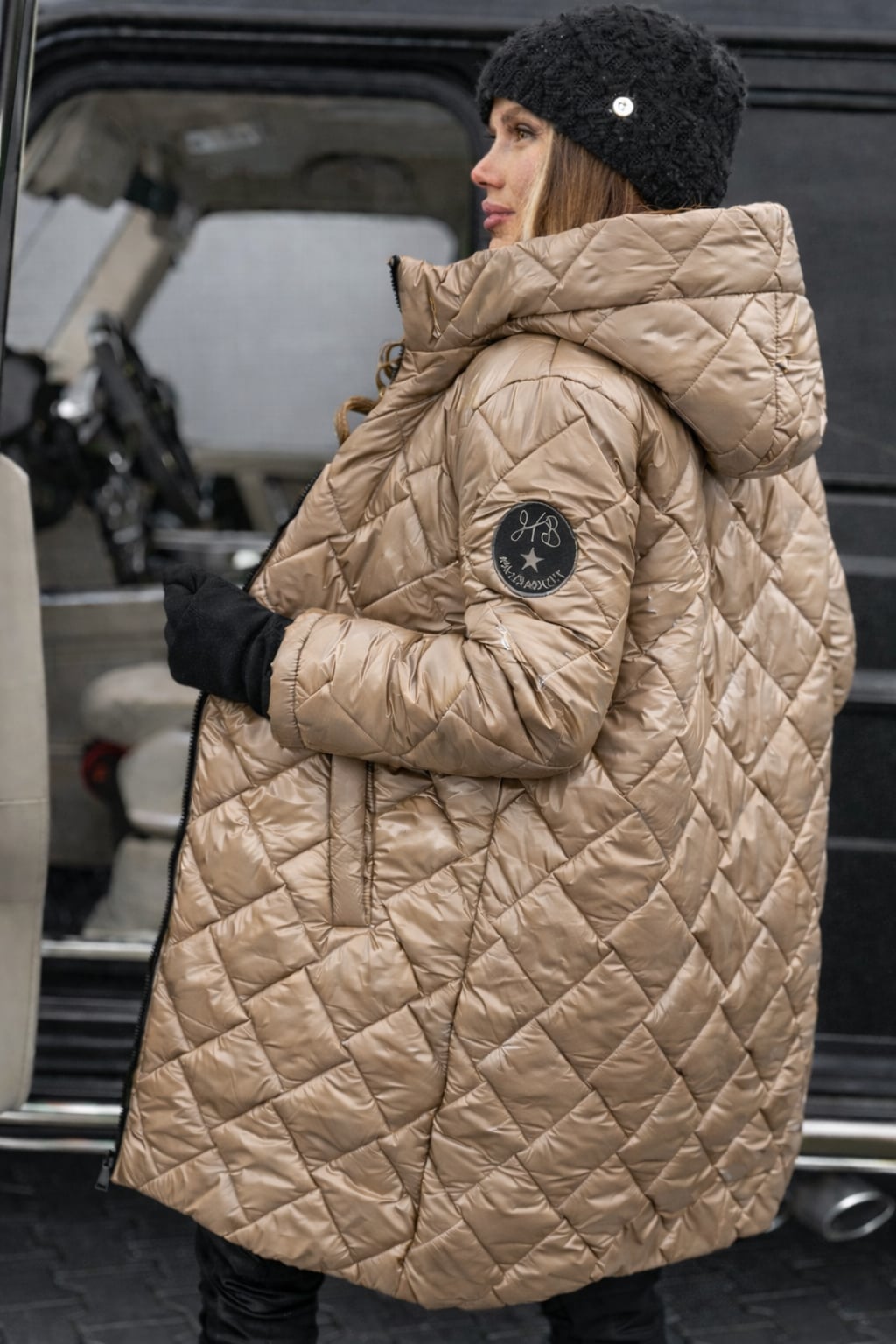 Side profile of the Riley quilted coat showing its sleek, modern shape