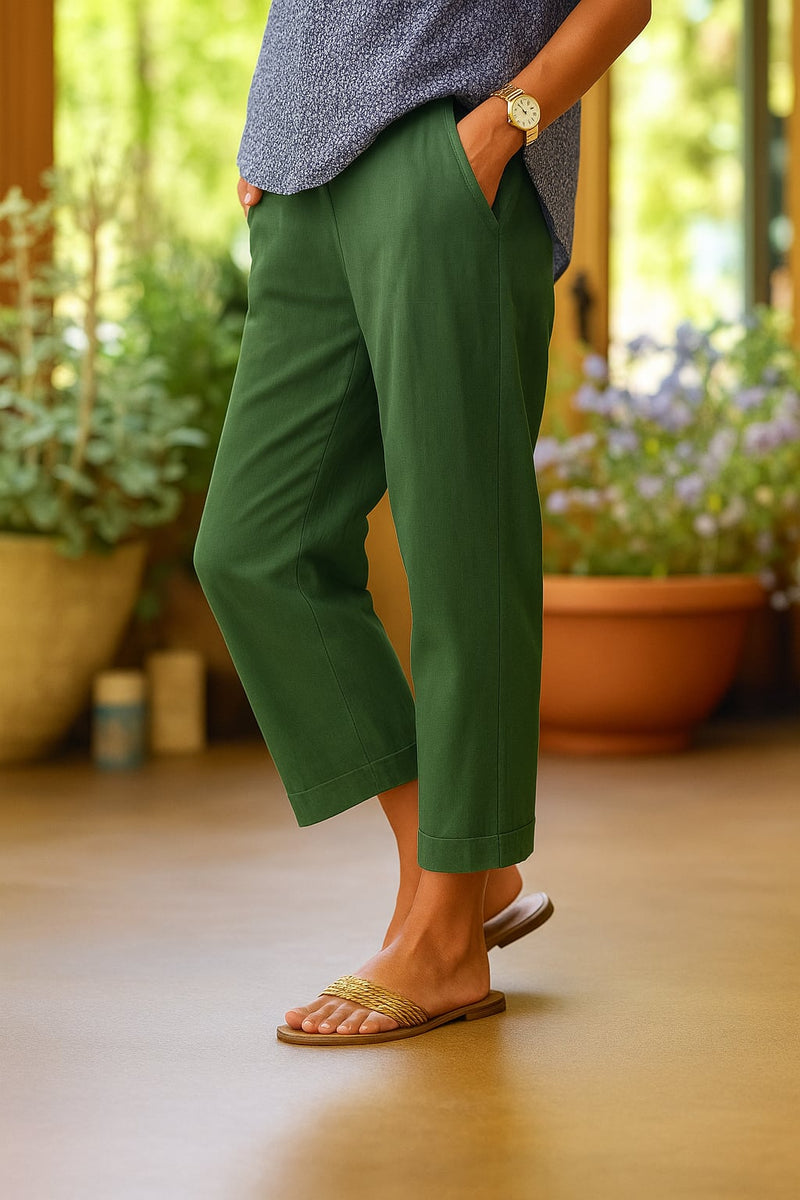 Model wearing white straight-leg trousers paired with a simple blouse in an outdoor setting