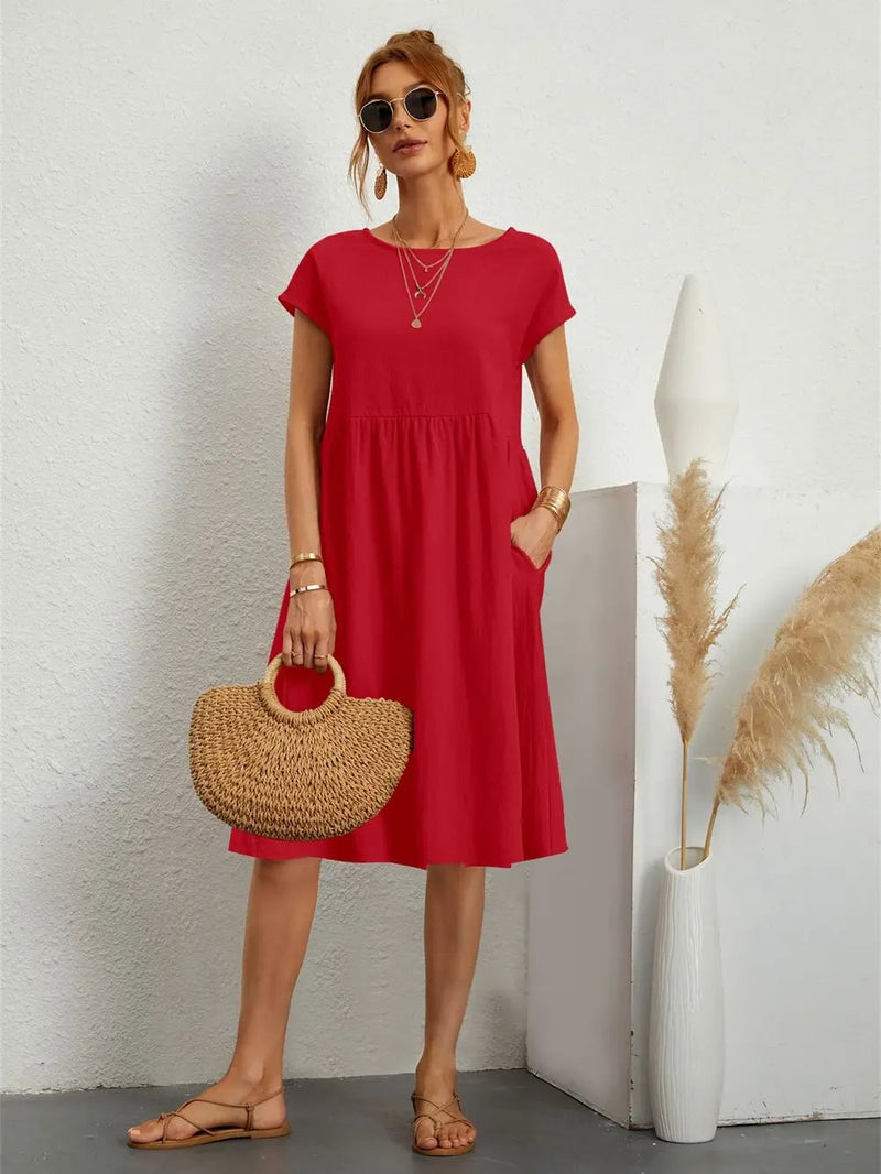 Woman wearing a relaxed casual pocket dress in a neutral color, styled with simple accessories for an everyday look