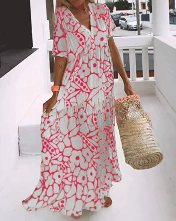 Model in a pink flowy A-line dress posing outdoors in summer sunlight