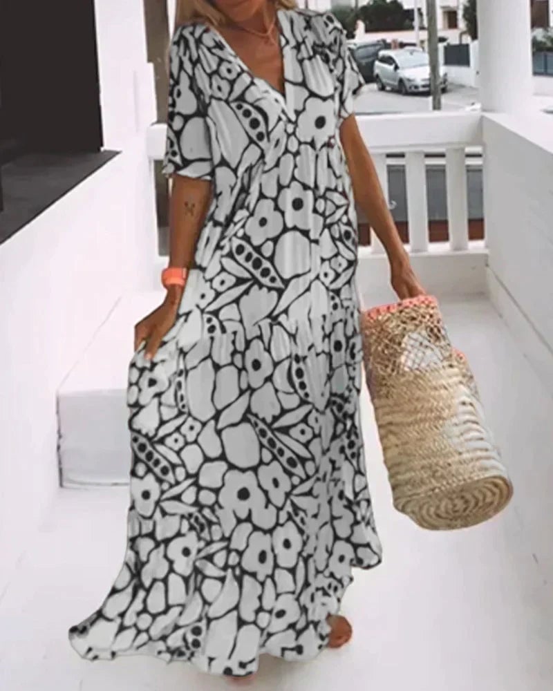 Back view of a woman in a black flowy V-neck A-line dress showing the relaxed silhouette