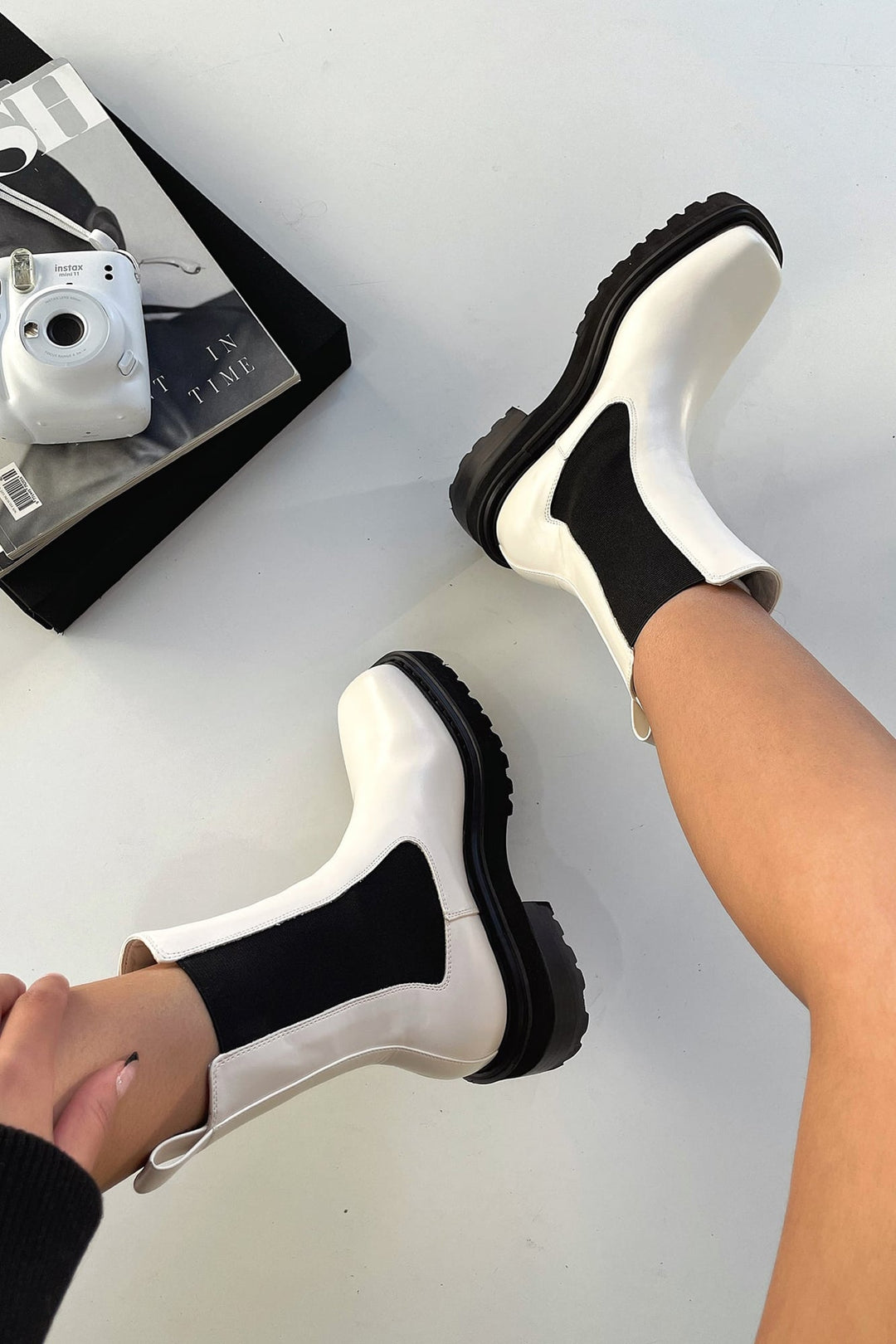 Front view of women's white two-tone ankle boots with sculpted ankle silhouette on a clean background