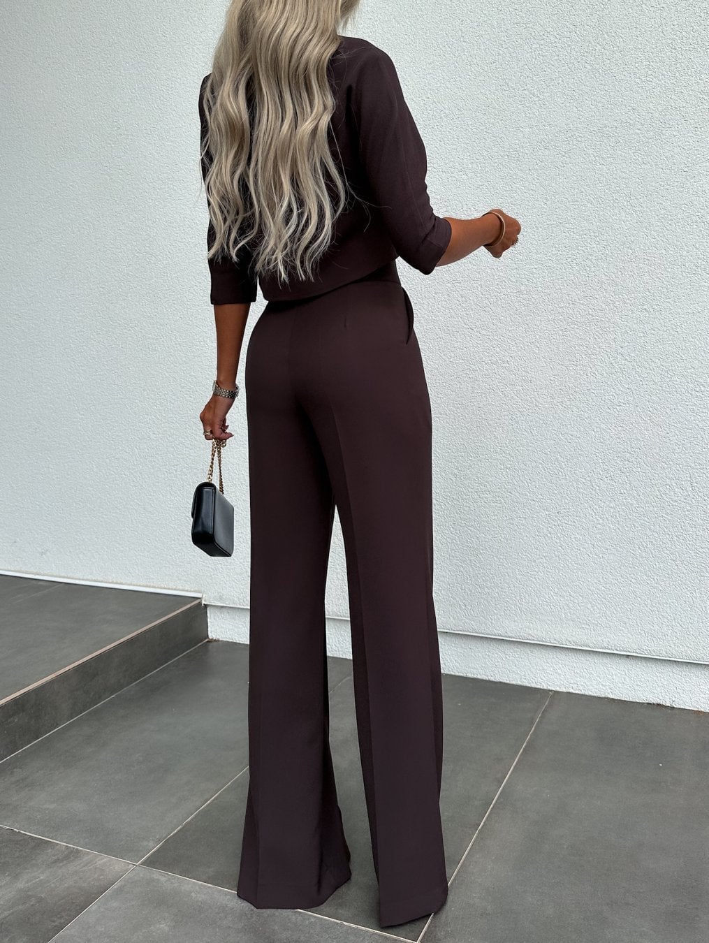 Model wearing the white two-piece lounge set in a relaxed seated pose