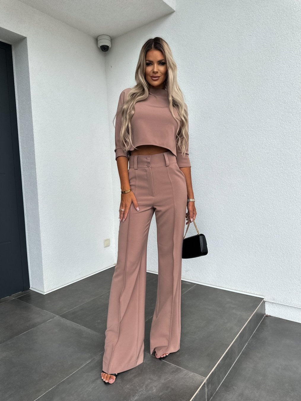 Woman in the black lounge set walking, showing the fluid drape of the relaxed-fit top