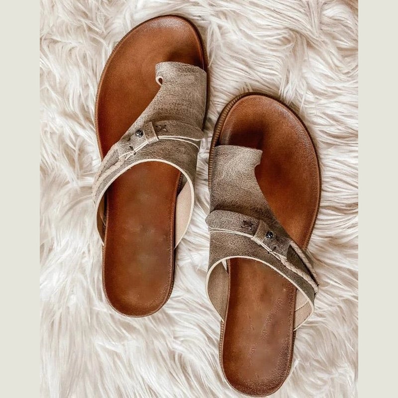 Roma toe ring sandals in black laid flat on a light neutral surface