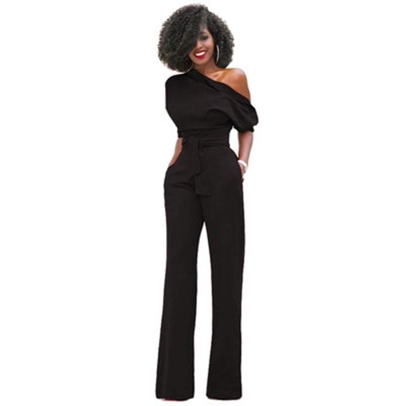 Woman wearing the Rosa off-shoulder wide-leg belted jumpsuit in red with a puff sleeve and floor-length wide-leg trousers