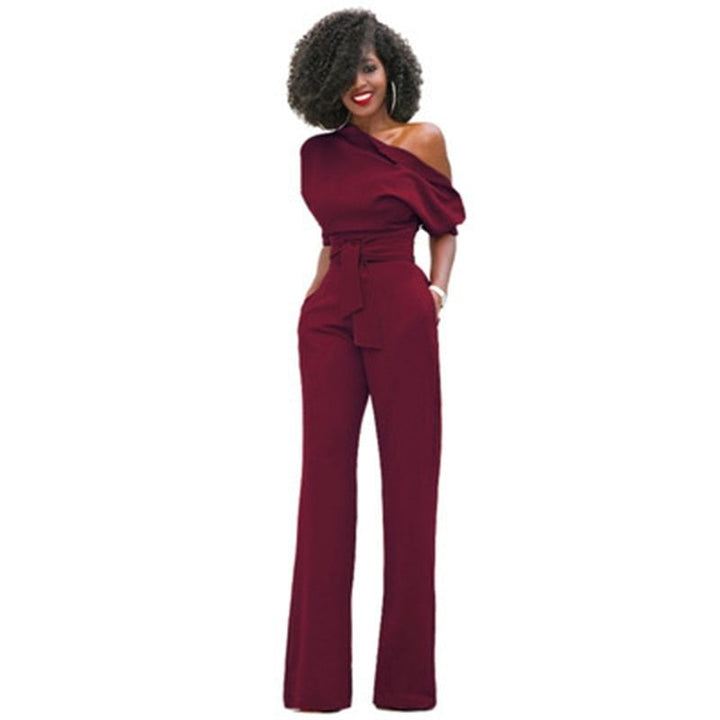 Full-length lifestyle shot of a woman in the Rosa belted wide-leg jumpsuit styled with strappy heels