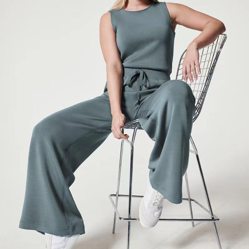 Woman posing in the Rosalie jumpsuit in blue, paired with heels for an elevated evening outfit