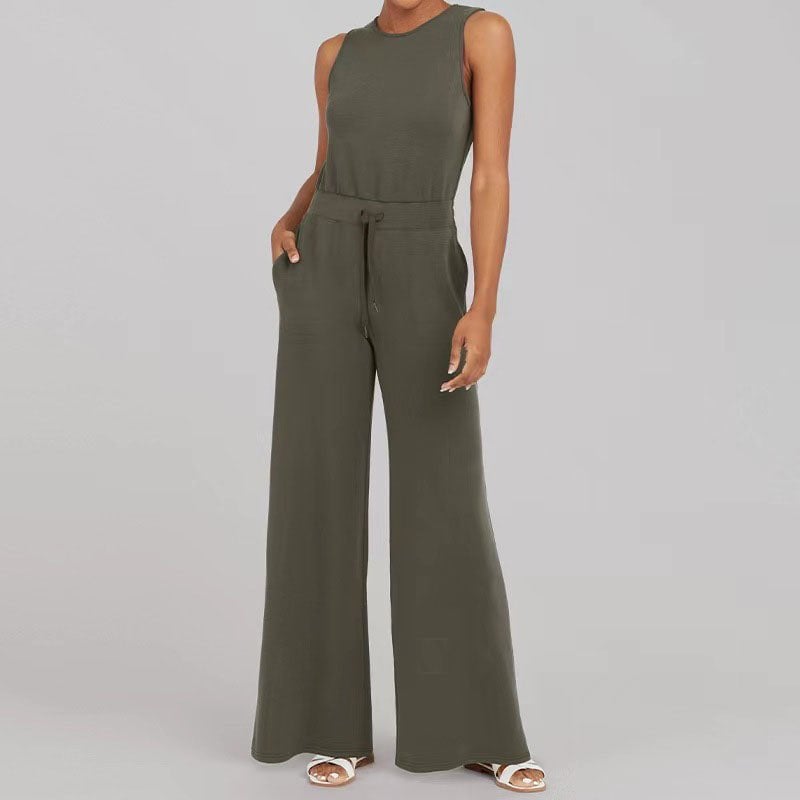 Woman wearing the dark green Rosalie jumpsuit with sneakers for a casual chic daytime look