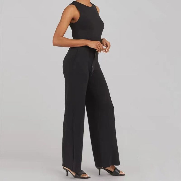 Full-length shot of the Rosalie jumpsuit in beige styled with statement accessories for a polished look