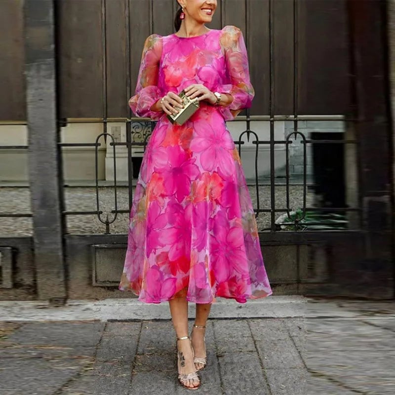 Woman wearing the Rosalie floral chiffon midi dress in pink with sheer puff long sleeves and a flowing A-line skirt