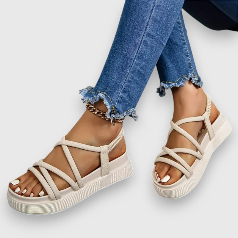 Rosalind beige sandals worn on feet against a light neutral background