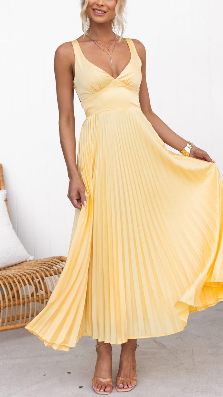 Woman wearing a yellow pleated V-neck maxi dress with a flowing full-length silhouette, front view