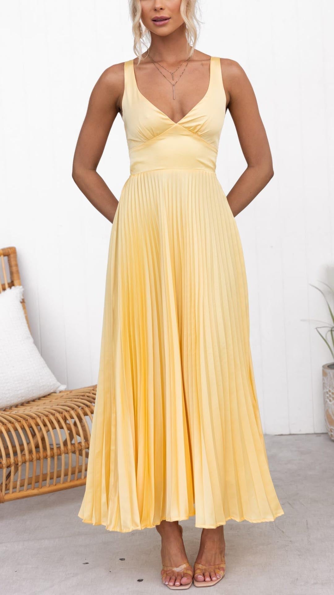 Close-up of the delicate pleated detailing and V-neckline on a yellow maxi dress