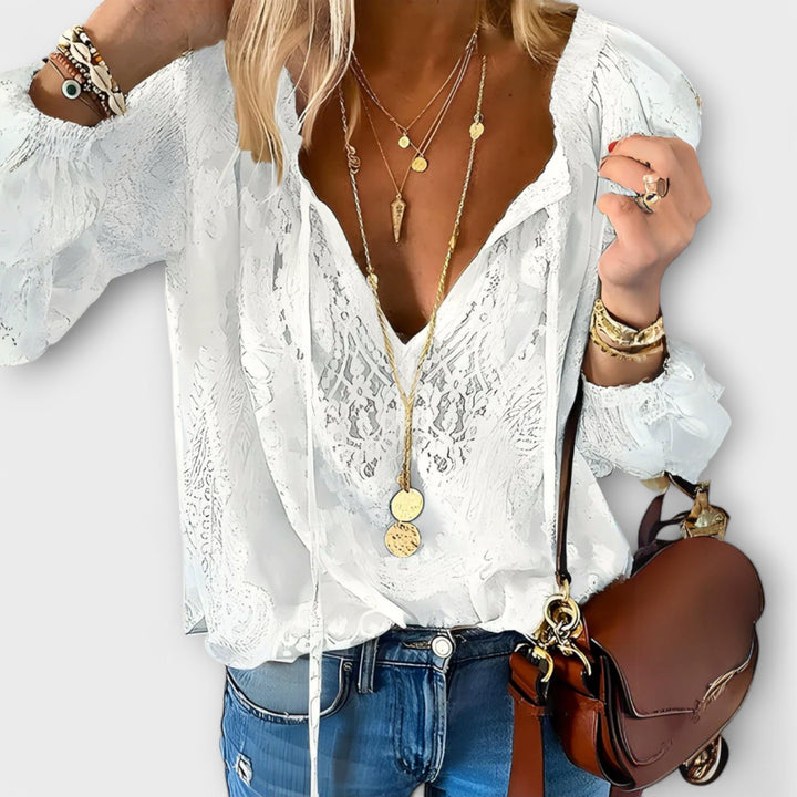 Woman wearing the Rosalynn white V-neck long sleeve lace blouse with a relaxed, feminine fit