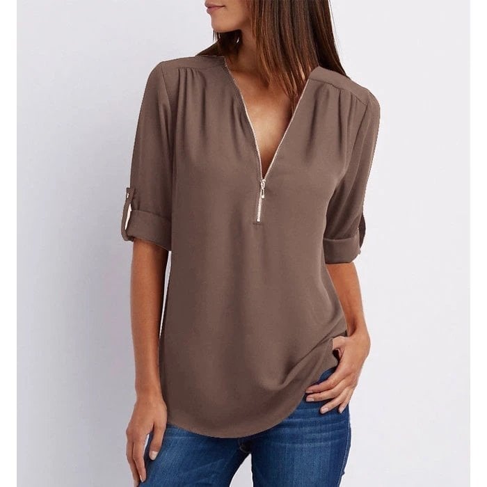 Model wearing the Rosé zip-up blouse in white paired with jeans for a casual everyday look