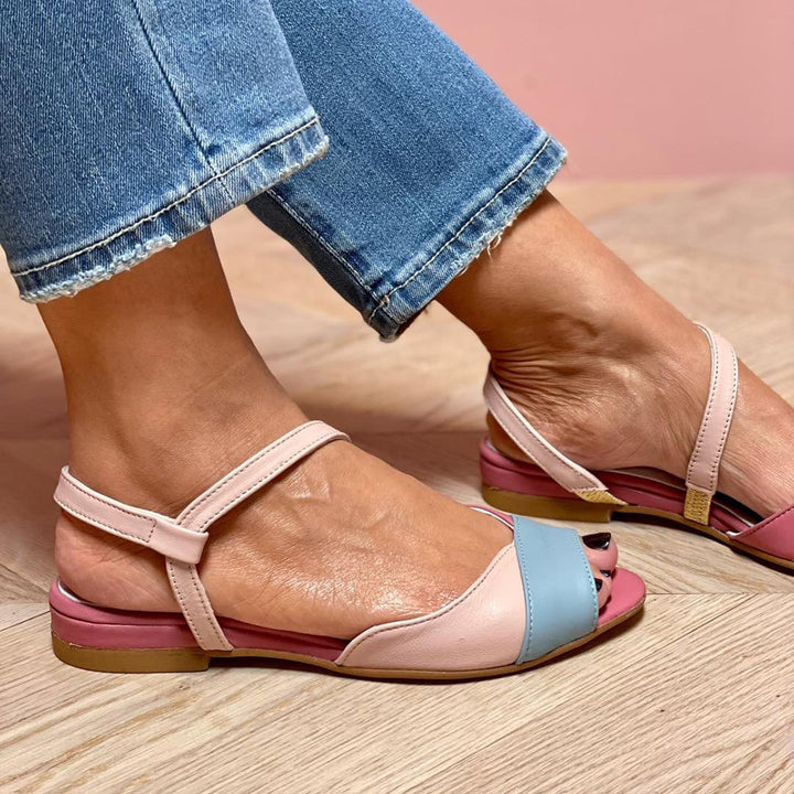 Side profile of pink color block sandals showing asymmetrical strap design and low stable heel