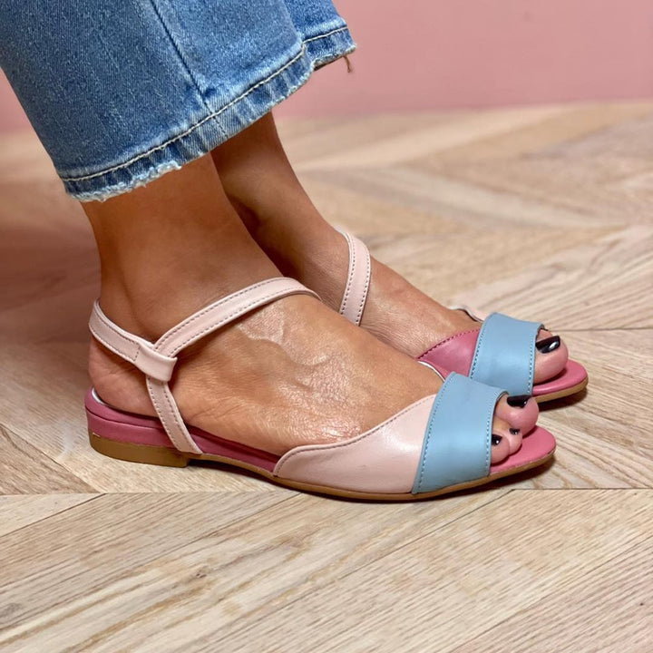 Lifestyle shot of pink asymmetrical color block sandals styled for a casual summer look