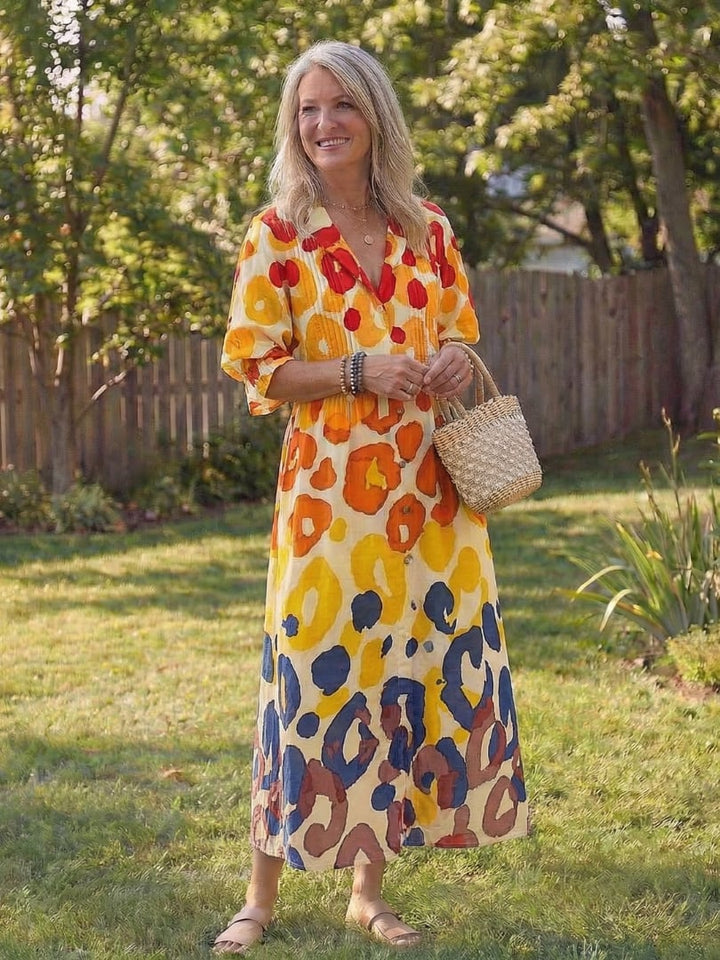 Model wearing Roselyn maxi dress at an outdoor garden setting, styled with a straw tote