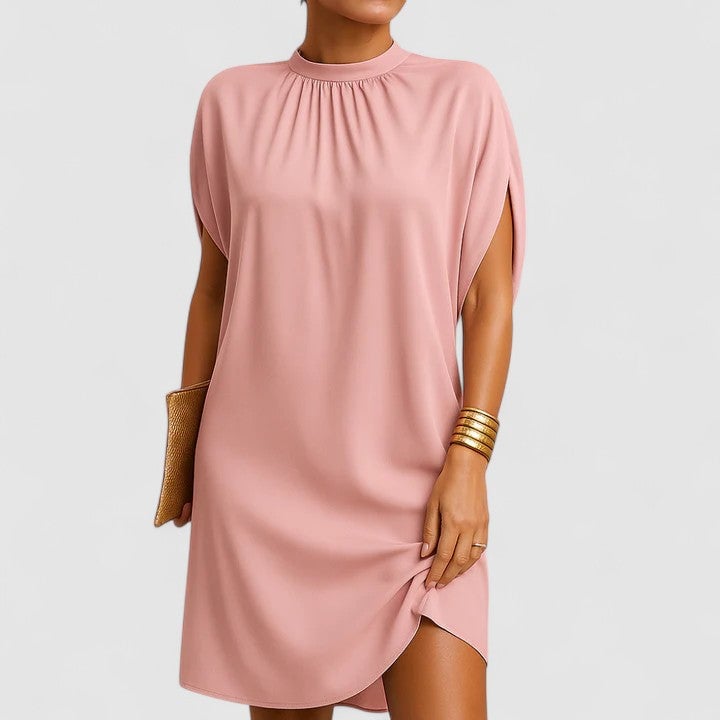 Woman wearing the Rosie mock neck batwing split sleeve midi dress in pink with a curved asymmetric hem