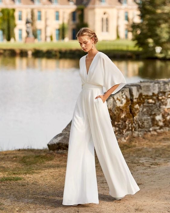 Women's wide-leg batwing jumpsuit with deep V-neckline in blush pink, full-length front view