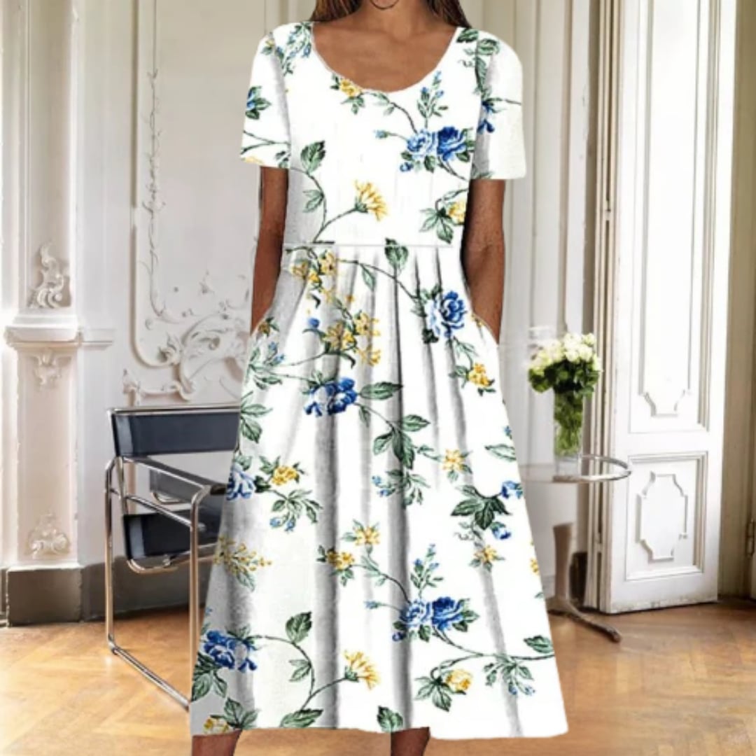 Ruby floral midi dress in blue petal print worn outdoors in natural light