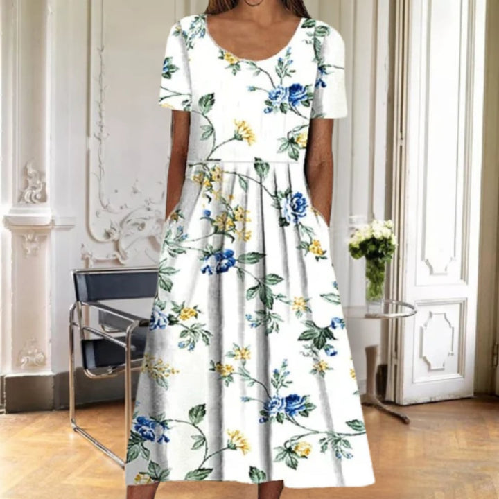 Ruby floral midi dress in blue petal print worn outdoors in natural light