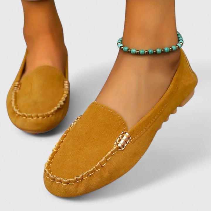 Overhead flat-lay of Ruby suede loafers in multiple colors showing color range