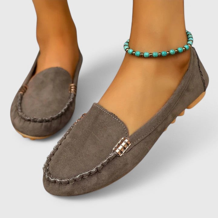 Ruby suede loafers in pink worn on feet, styled with white jeans