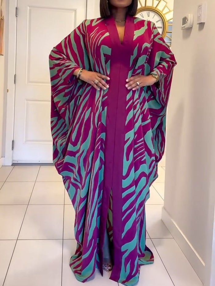 Woman wearing a purple zebra print V-neck batwing sleeve maxi dress with a flowing robe silhouette and hem split