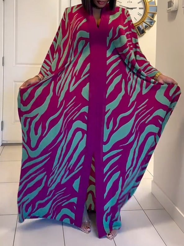 Side view of a purple zebra print maxi dress highlighting the flowing batwing sleeves and elegant hem split