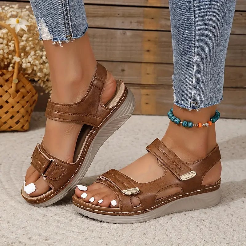 Close-up of Rue adjustable sandal straps in brown showing buckle closure detail