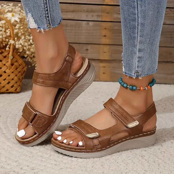 Close-up of Rue adjustable sandal straps in brown showing buckle closure detail