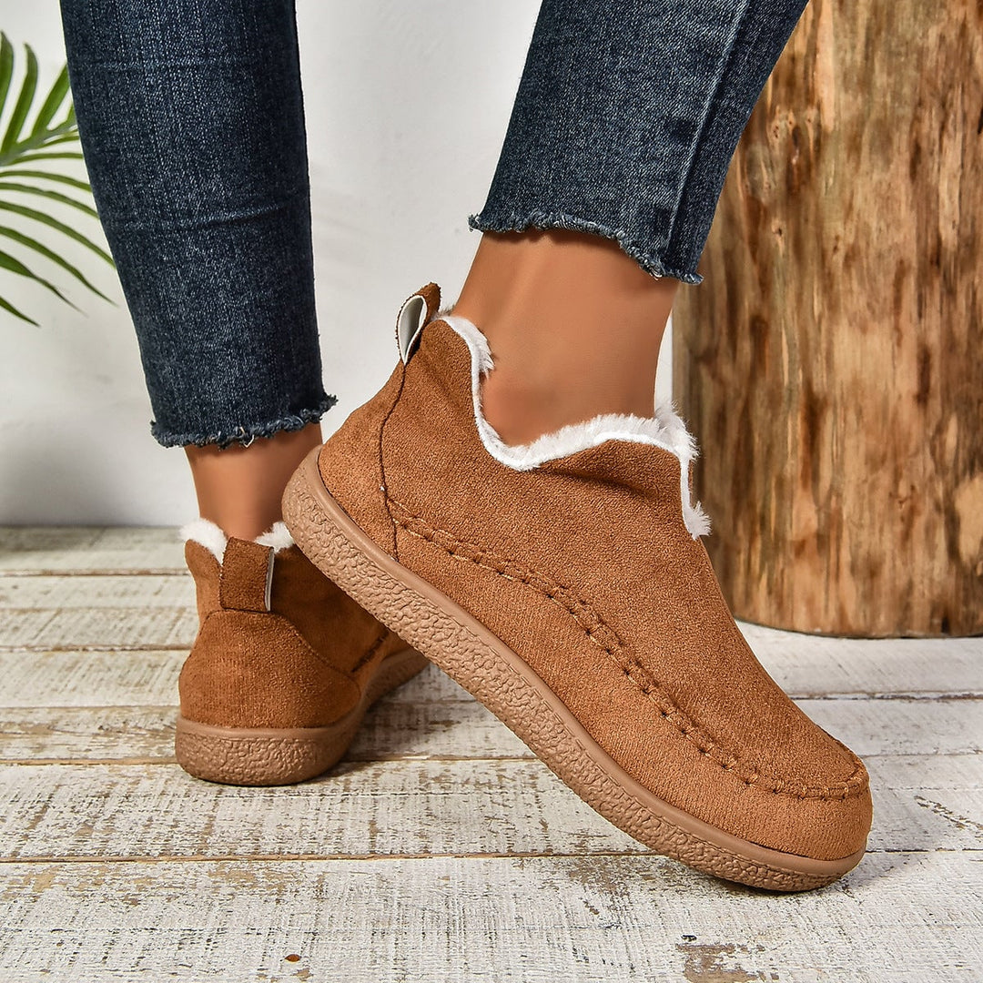 Women wearing brown fur-lined slip-on ankle boots styled with skinny jeans
