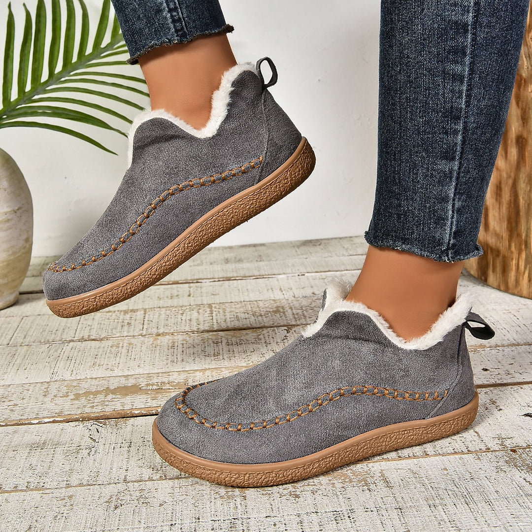 Beige fur-lined ankle boots showing smooth contoured upper and slip-on opening