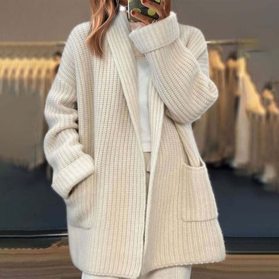 Woman wearing a beige open-knit cardigan with a relaxed, flowing silhouette over a casual outfit