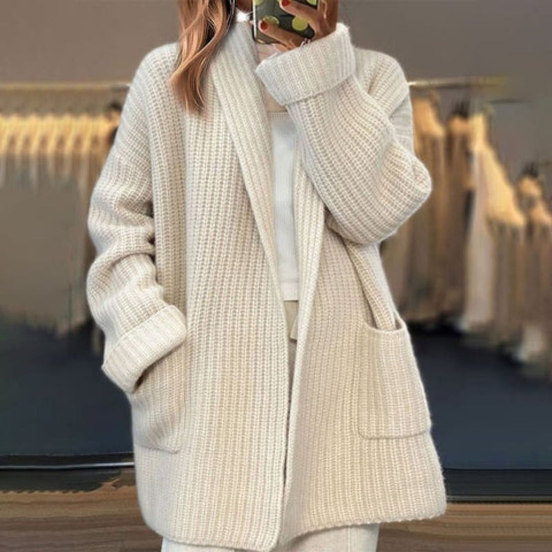 Woman wearing a beige open-knit cardigan with a relaxed, flowing silhouette over a casual outfit