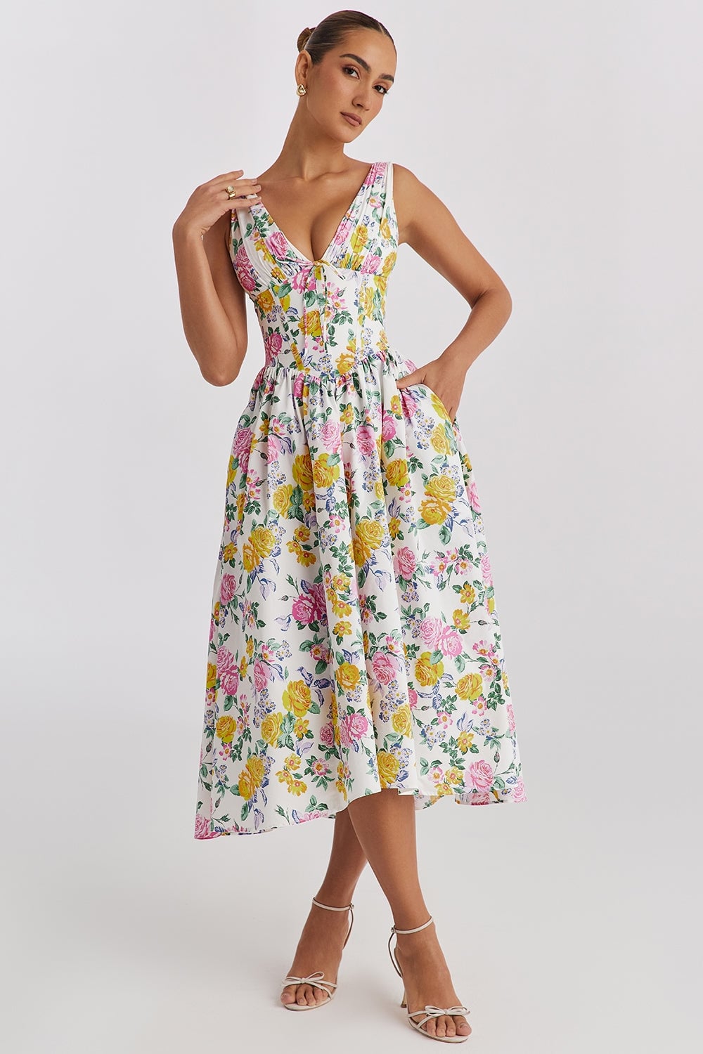 Woman wearing the Saffron yellow floral summer dress with a flowing silhouette and waist-defining fit