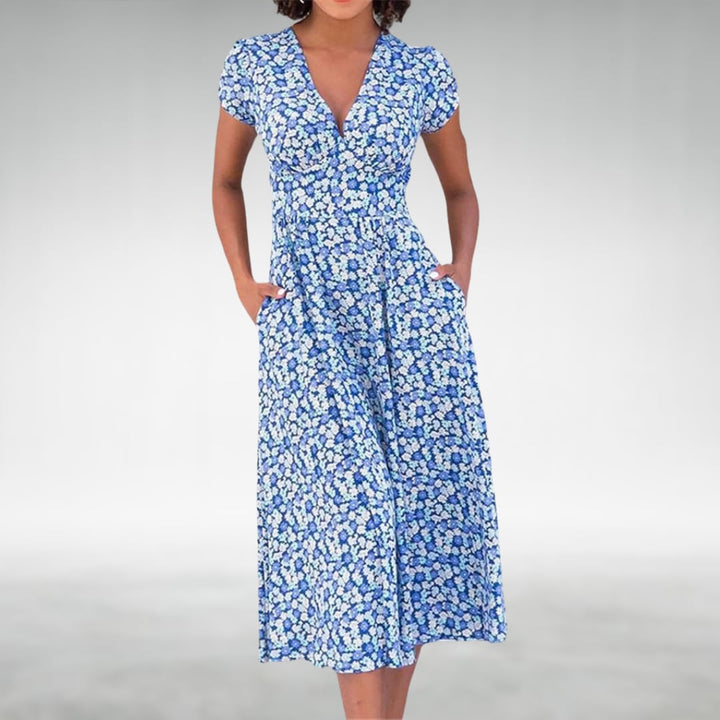 Woman wearing a floral V-neck midi dress with short sleeves in a blue print, styled for a casual summer outing