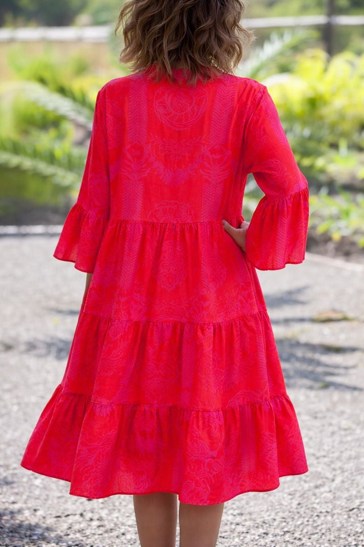 Back view of a woman in a turquoise boho flowy draped dress with airy flowing silhouette