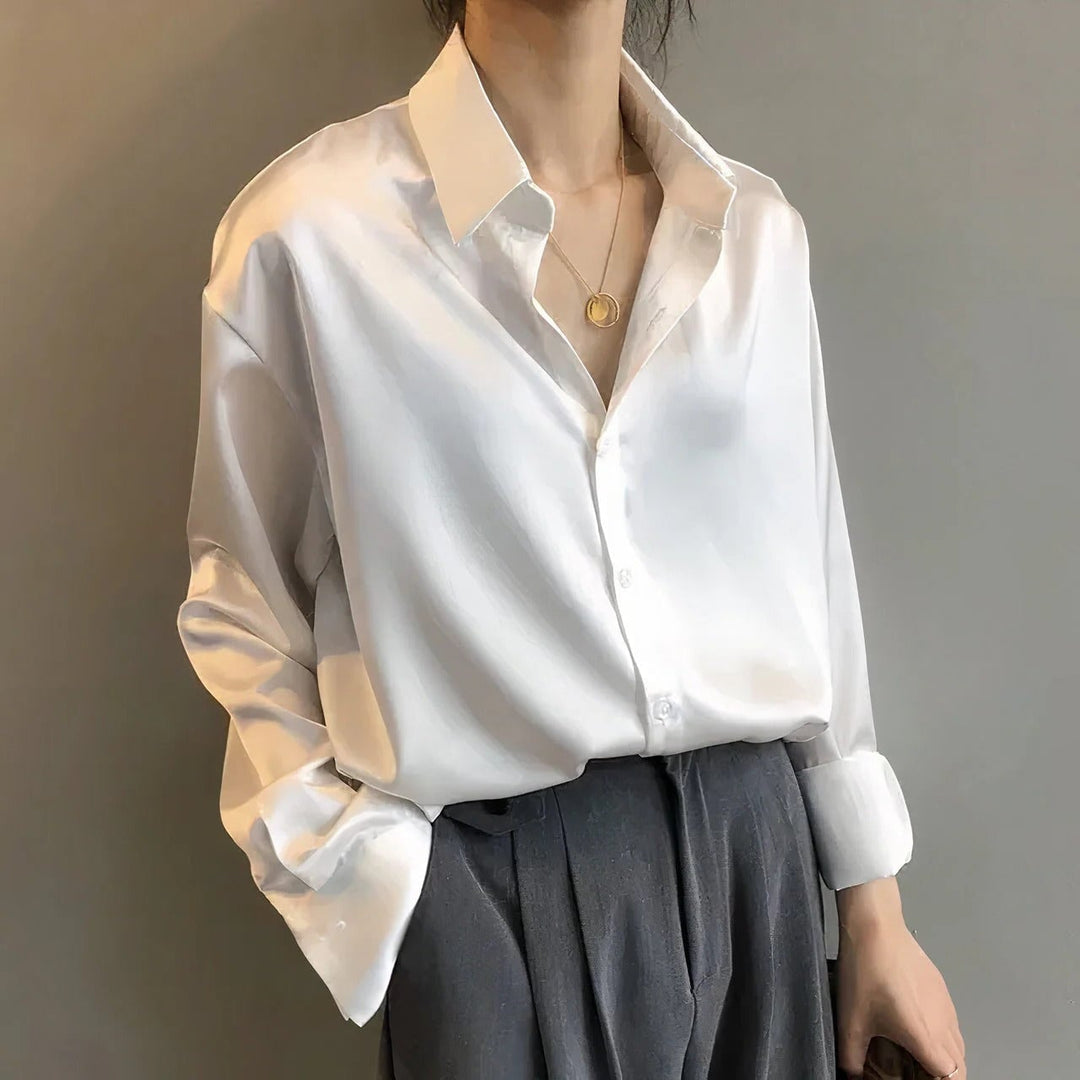 Close-up of satin blouse button placket and pointed collar showing luminous fabric finish