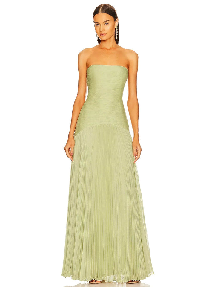 Woman wearing a sage green strapless pleated maxi formal gown with a dropped waist and floor-length skirt