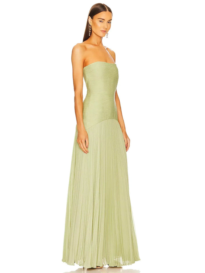 Side view of the sage green pleated maxi gown highlighting the flowing skirt movement
