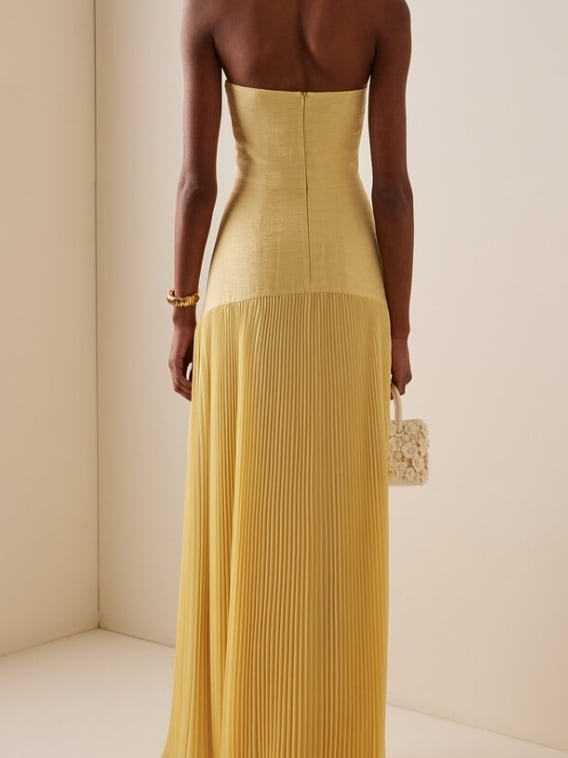 Front view of the yellow strapless pleated maxi evening gown with dropped waist detail