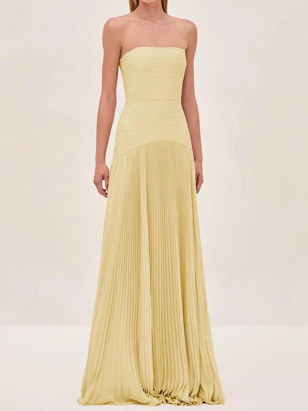 Side profile of the yellow formal maxi gown showing the elegant A-line shape and pleated hem