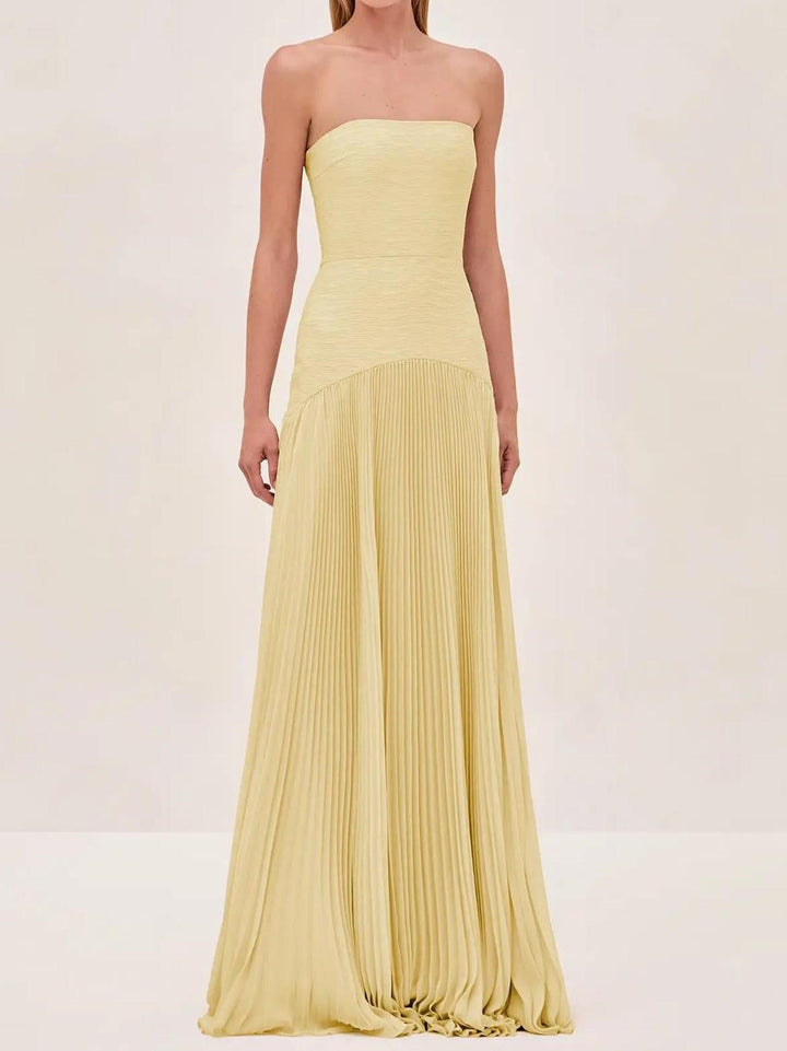 Side profile of the yellow formal maxi gown showing the elegant A-line shape and pleated hem