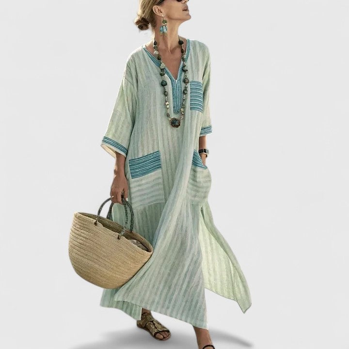 Women's striped linen maxi dress with V-neckline, teal embroidered trim, and patch pockets — front view