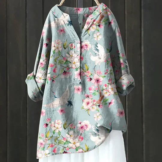 Woman wearing a light blue airy relaxed-fit top with a loose, breezy silhouette against a bright summer background
