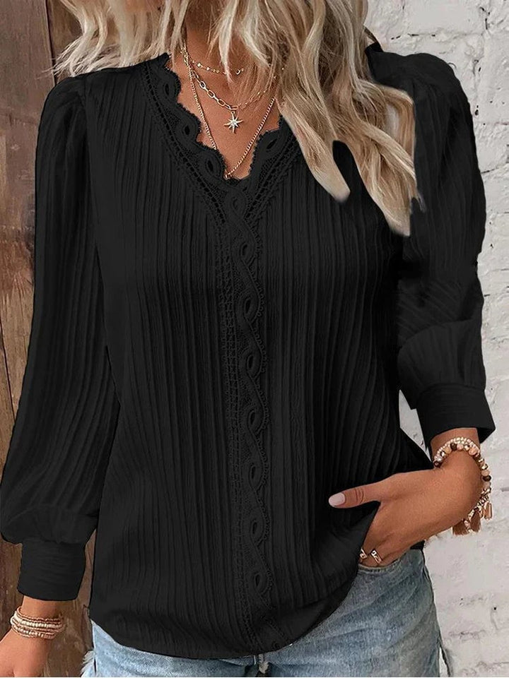 Woman wearing a lightweight white chiffon blouse with intricate lace detailing at the neckline and front panel